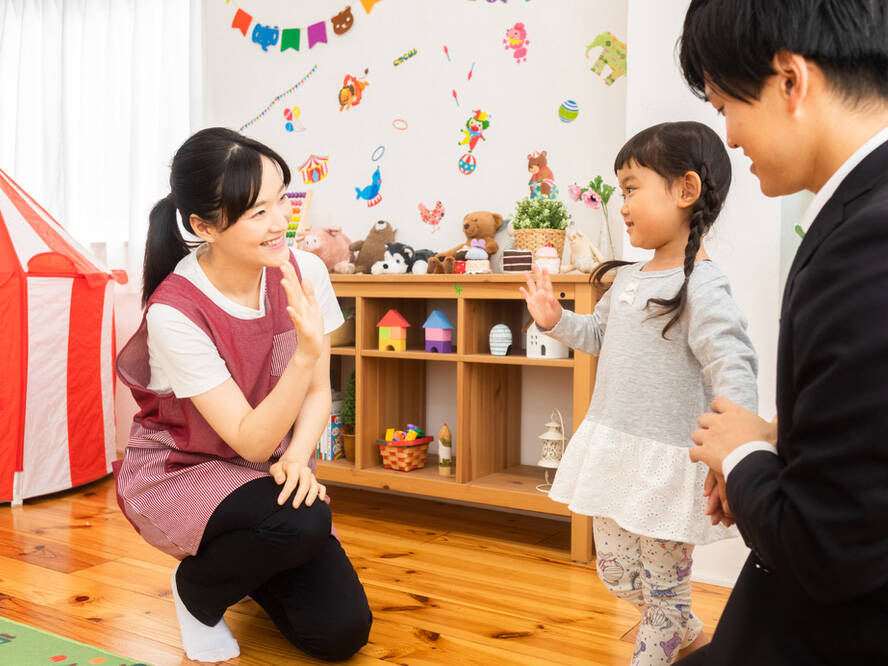 Teacher waving to parent and young student